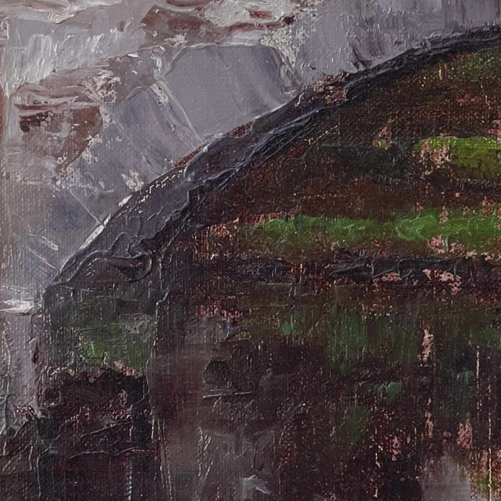 Detail of a landscape oil painting of a stone bridge over a river with autumn-colored grasses in the foreground displayed on a wall.