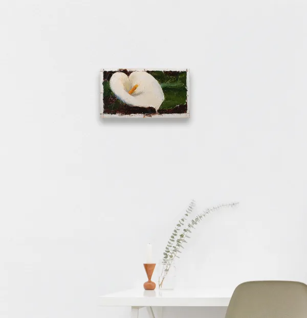 Oil painting of a white calla lily with yellow pistol tightly framed in warm dark brown background displayed on a wall.