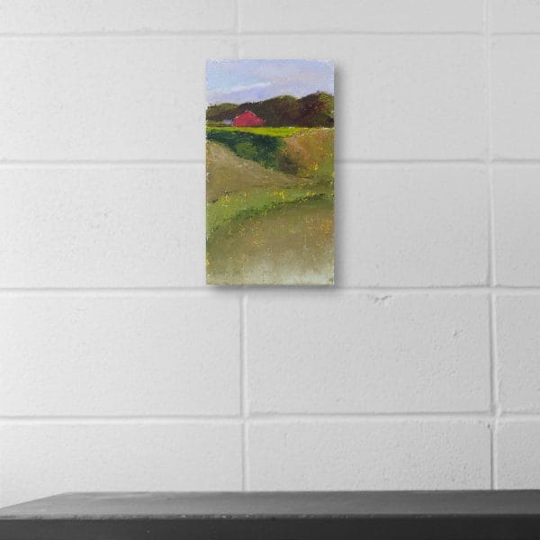 An oil painting of a red barn set in a green hilly landscape displayed on a wall.