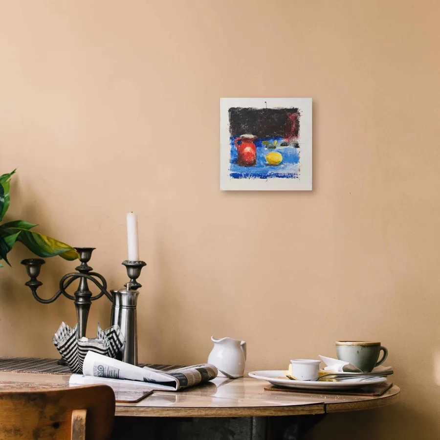 Oil painting of a red pitcher and a yellow lemon on a blue cloth with a dark fabric background.