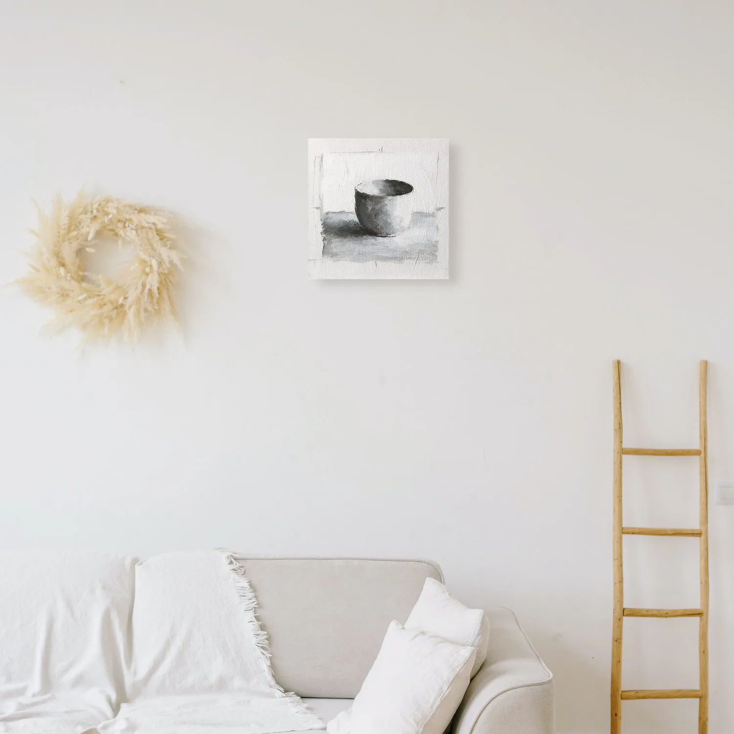 Monochromatic oil painting of a white cup on a white background with black and grey shadows displayed on a wall.