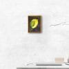 An oil painting of a yellow calla lily, placed against a warm green and dark violet background as displayed on an interior wall.