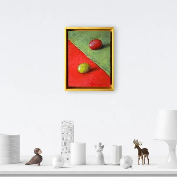 An oil painting of a green grape on red fabric juxtaposed with a red grape on a green fabric as displayed on an interior wall.