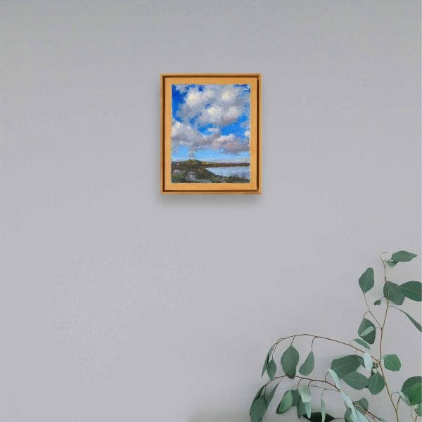An oil painting of white puffy clouds in a deep blue sky rising above the Cerro Pedernal, near Ghost Ranch, Abiquiu, almost seem as if the clouds emerge from this ancient volcanic formation in this landscape of water, mountains, clouds, and sky as displayed on an interior wall.