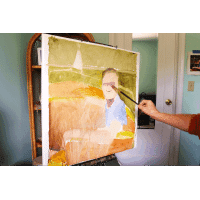 Canvas, paint and brushes used in creating a portrait painting of a young man on boat.