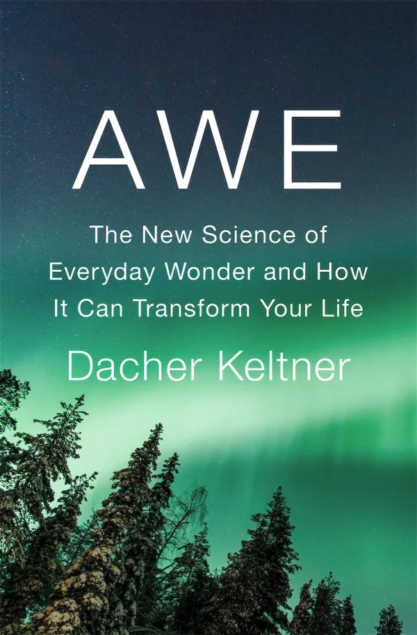 Cover illustration for the book 'Awe' by Dacher Keltner, showing a turquoise-green aurora borealis in the night sky silhouetted by dark pine trees in the lower-left foreground.