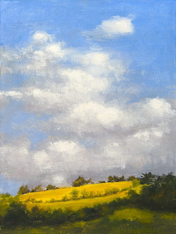 An oil painting of blue sky, white clouds, above a brightly lit field of yellow grain surrounded by dark green woods.
